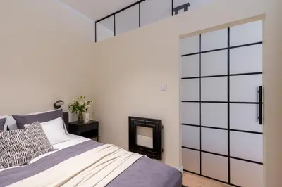 a bedroom with a bed and a large glass door at Cozy Corner by Cozyplace in Kraków