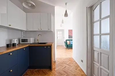 a kitchen with white cabinets and a blue counter top at Urban Nest Apartments Starowiślna 30A in Kraków
