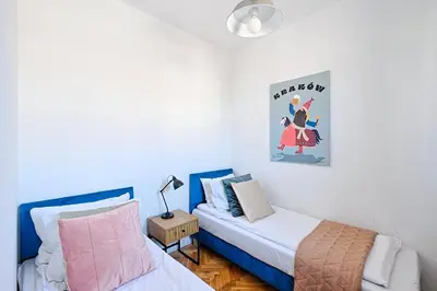 a bedroom with two beds and a table with a lamp at Urban Nest Apartments Starowiślna 30A in Kraków