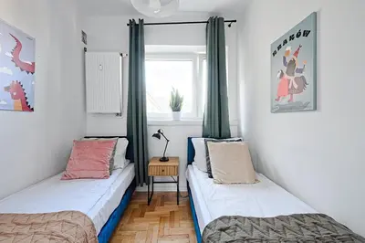 two beds in a room with a window at Urban Nest Apartments Starowiślna 30A in Kraków