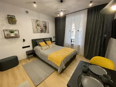 a bedroom with a bed and a table and chairs at St. Cross Apartment in Kraków