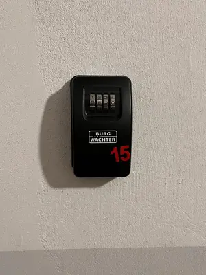 a black electrical outlet on a white wall at St. Cross Apartment in Kraków
