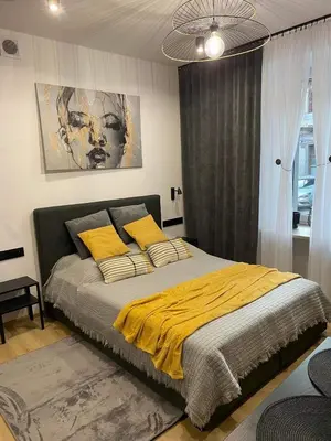 a bedroom with a bed with a yellow blanket at St. Cross Apartment in Kraków