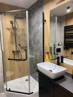 a bathroom with a sink and a glass shower at St. Cross Apartment in Kraków