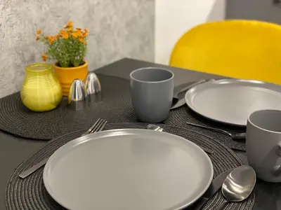 a table with two white plates and two cups and spoons at St. Cross Apartment in Kraków