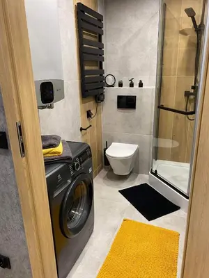 a bathroom with a washing machine and a toilet at St. Cross Apartment in Kraków