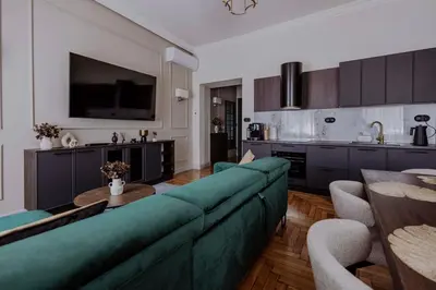 a living room with a green couch and a kitchen at Crown Pearl - wonderful apartment, 110scm, 4 rooms in Kraków