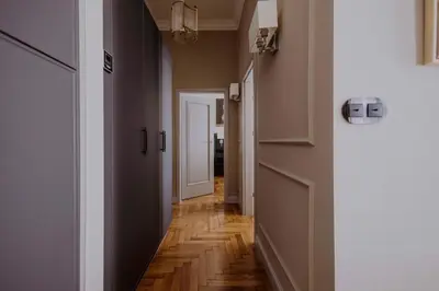 a hallway with wood floors and a white door at Crown Pearl - wonderful apartment, 110scm, 4 rooms in Kraków