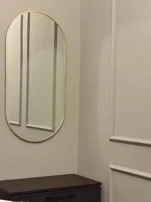 a mirror on a wall next to a wooden table at Crown Pearl - wonderful apartment, 110scm, 4 rooms in Kraków