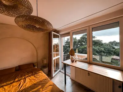 a bedroom with a bed and a large window at Sunset Stories Old Town Apartment in Kraków