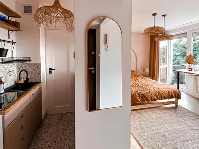 a kitchen with a door leading to a bedroom at Sunset Stories Old Town Apartment in Kraków