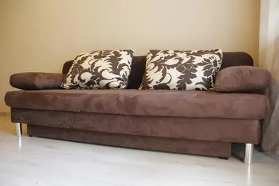 a brown couch with two pillows on top of it at Apartment Widok in Kraków