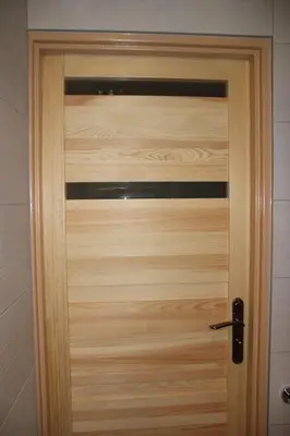 a wooden door with a black handle in a room at Apartment Widok in Kraków