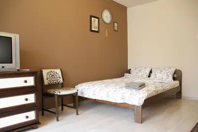 a bedroom with a bed and a tv and a chair at Apartment Widok in Kraków