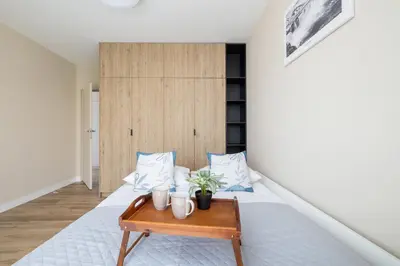 a bedroom with a bed with a table at Tauron Arena Crakow Apartment with Parking by Noclegi Renters in Kraków