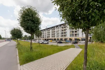 a sidewalk with trees in front of a building at Tauron Arena Crakow Apartment with Parking by Noclegi Renters in Kraków