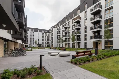a courtyard of an apartment building with benches and bikes at Tauron Arena Crakow Apartment with Parking by Noclegi Renters in Kraków