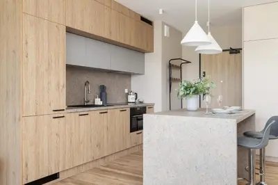 a kitchen with wooden cabinets and a counter top at Tauron Arena Crakow Apartment with Parking by Noclegi Renters in Kraków