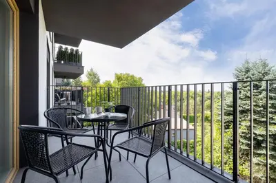 a patio with a table and chairs on a balcony at Tauron Arena Crakow Apartment with Parking by Noclegi Renters in Kraków