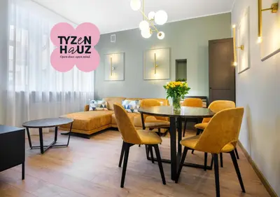 a living room with a table and chairs and a couch at Tyzenhauz Apartments Pawia Street in Kraków