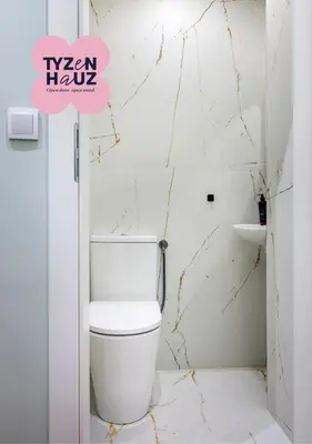 a bathroom with a white toilet in a room at Tyzenhauz Apartments Pawia Street in Kraków