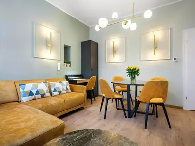 a living room with a couch and a table and chairs at Tyzenhauz Apartments Pawia Street in Kraków