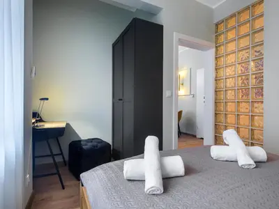 a bedroom with a bed with white towels on it at Tyzenhauz Apartments Pawia Street in Kraków