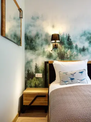 a bedroom with a bed with a painting on the wall at Tyzenhauz Apartments Pawia Street in Kraków
