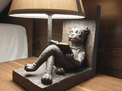 a statue of a dog sitting down reading a book at F-3 Kraków Rynek-Wawel O&P ApartFamily in Kraków