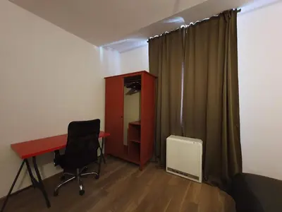 a room with a desk and a chair and a cabinet at F-3 Kraków Rynek-Wawel O&P ApartFamily in Kraków
