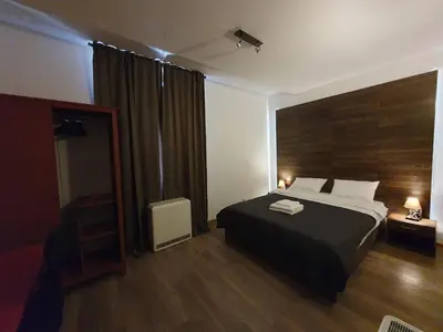 a bedroom with a black bed and a wooden wall at F-3 Kraków Rynek-Wawel O&P ApartFamily in Kraków