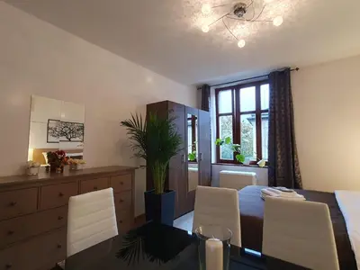 a dining room with a table and white chairs at F-3 Kraków Rynek-Wawel O&P ApartFamily in Kraków