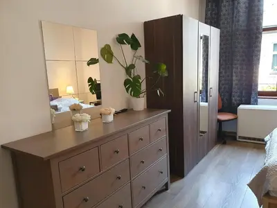 a dresser with plants on it in a bedroom at F-3 Kraków Rynek-Wawel O&P ApartFamily in Kraków