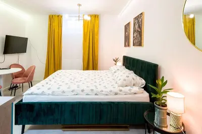 a bedroom with a large bed with a green headboard at Cosy and Stylish apartment in Kraków