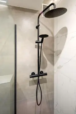 a shower with a glass door and a shower head at Cosy and Stylish apartment in Kraków