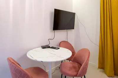 a room with a table with chairs and a tv at Cosy and Stylish apartment in Kraków