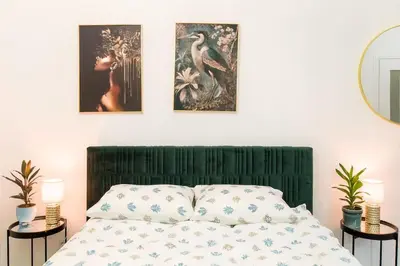 a bedroom with a bed and three paintings on the wall at Cosy and Stylish apartment in Kraków