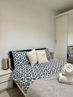 a bedroom with a bed with blue and white pillows at Apartament Guziczek in Nowy Targ