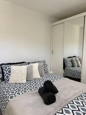 a bedroom with a bed with black towels on it at Apartament Guziczek in Nowy Targ
