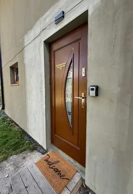 a brown door with a welcome mat in front of it at Apartament Guziczek in Nowy Targ