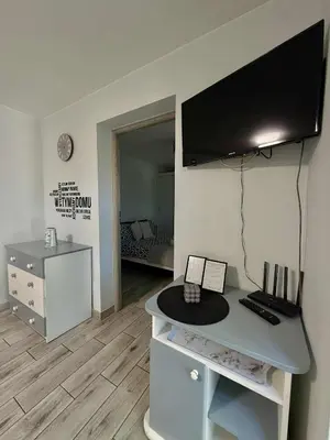 a room with a desk with a television on a wall at Apartament Guziczek in Nowy Targ