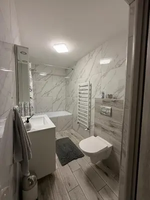 a bathroom with a toilet and a sink and a tub at Apartament Guziczek in Nowy Targ