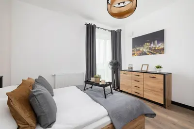 a living room with a white couch and a dresser at Kopiec Kraka Podgórze with Parking by Noclegi Renters in Kraków