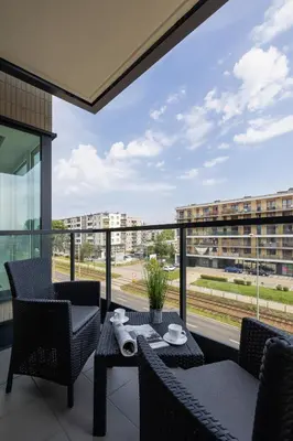 a balcony with a table and chairs and a large window at Kopiec Kraka Podgórze with Parking by Noclegi Renters in Kraków