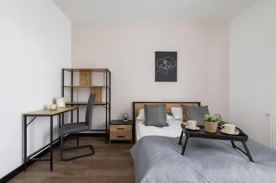 a bedroom with a bed and a desk and a table at Kopiec Kraka Podgórze with Parking by Noclegi Renters in Kraków