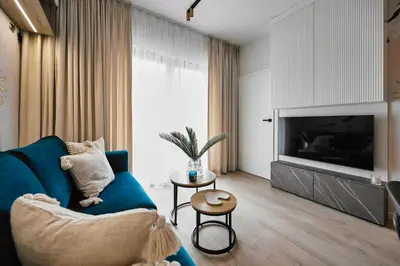 a living room with a blue couch and a television at Golden Dreams Luxury Apartment 81 in Kraków