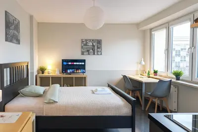 a bedroom with a bed and a desk with a computer at Balcony Studio Krakow City Center & Old Town in Kraków