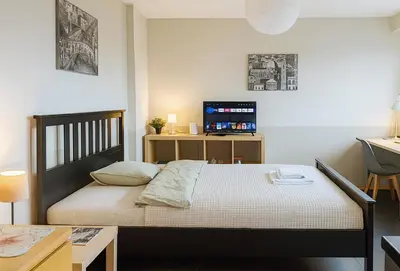 a bedroom with a bed with a desk and a television at Balcony Studio Krakow City Center & Old Town in Kraków