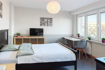 a bedroom with a bed and a desk with a computer at Balcony Studio Krakow City Center & Old Town in Kraków