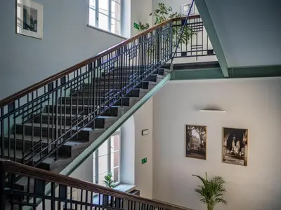 a spiral staircase in a building with plants at Dom Profesorski im. Stanisława Pigonia in Kraków